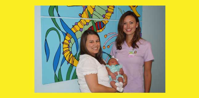 Meredith Buck and Nicole Pace, Certified Lactation Counselors smiling and one of them is holding a newborn baby in her arms