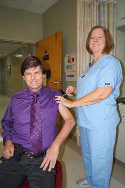 Picture of female nurse giving a male patient a shot