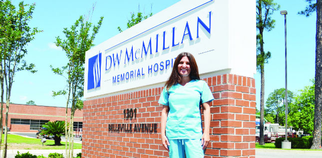 This is a picture of the DW McMillan Hospital sign with nutritionist Stephanie Ball.